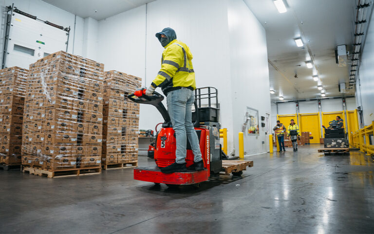 worker on forklift in produce storage building