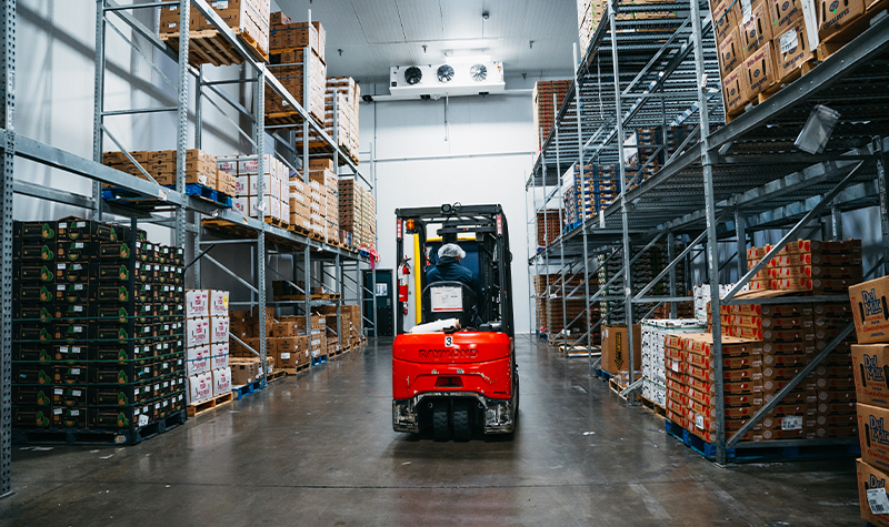 worker on forklift in produce storage building