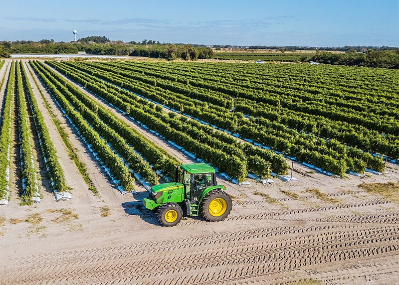 Green tractor in front of field