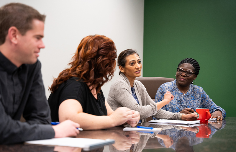 team sitting at table in discussion